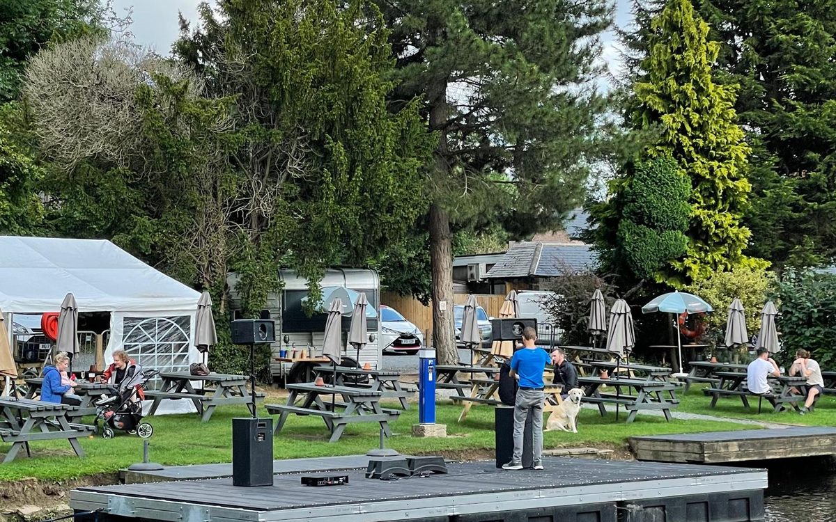 Floating event stage trimaran raft at a riverside pub